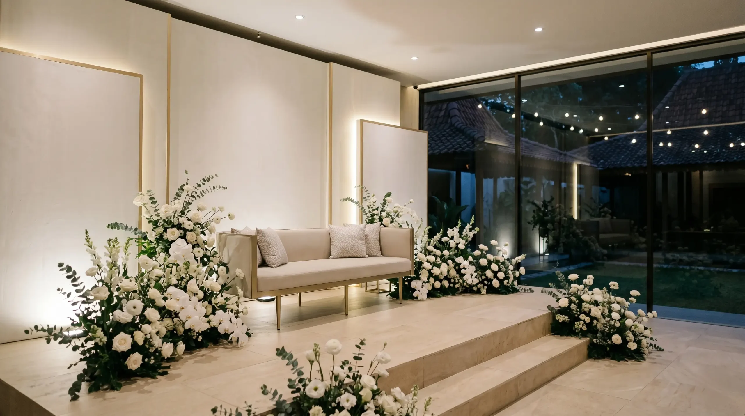 Dekorasi pelaminan minimalis modern dengan backdrop ivory dan lighting hangat